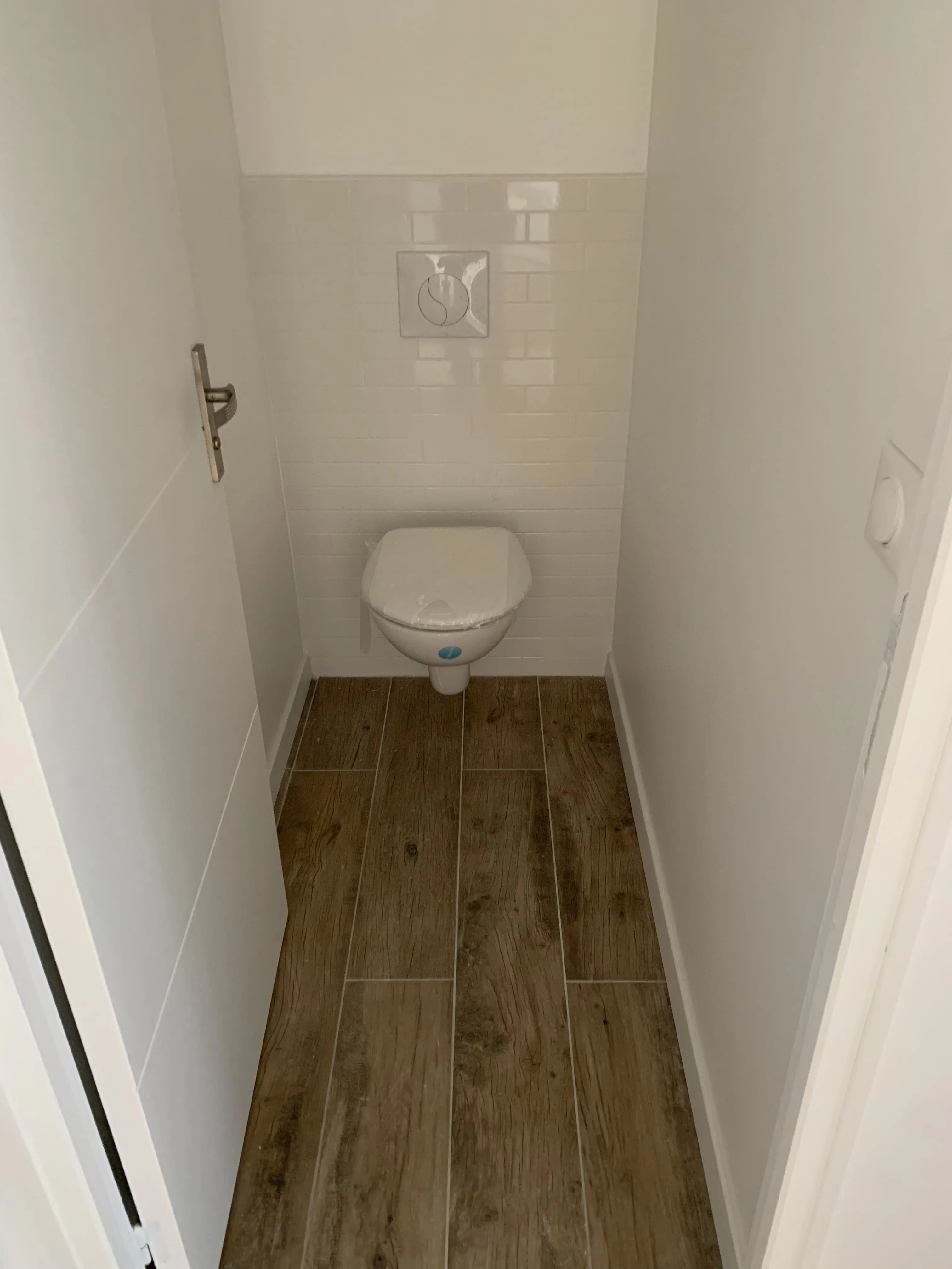 Toilette carrelage blanc et parquets